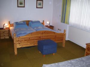 a bedroom with a large wooden bed with blue pillows at Log Home in Mauterndorf