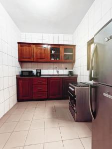 una cucina con armadi rossi e frigorifero in acciaio inossidabile di ORADYS RESIDENCE 