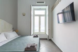 Una habitación blanca con una cama y una ventana. en Napoli Relax Rooms Chiaia - Mergellina - Posillipo, en Nápoles