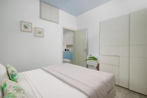 ein weißes Schlafzimmer mit einem Bett und weißen Schränken in der Unterkunft Votsalo Blue in Ierápetra