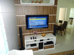 ein Wohnzimmer mit einem Fernseher an der Wand in der Unterkunft A15 - APARTAMENTO 2 DORMITÓRIOS NO CENTRO DE BOMBINHAS ALUGUEL DE TEMPORADA in Bombinhas