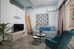 ein Wohnzimmer mit einem Sofa und einem TV in der Unterkunft Votsalo Blue in Ierápetra