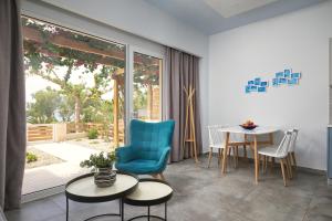 ein Wohnzimmer mit einem blauen Stuhl und einem Tisch in der Unterkunft Votsalo Blue in Ierápetra
