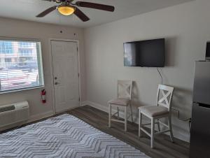 a living room with two chairs and a flat screen tv at The Pointe at Daytona Beach Shores in Daytona Beach Shores