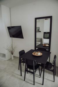 a black dining room table with chairs and a mirror at Studio apartment G13 in Đakovo