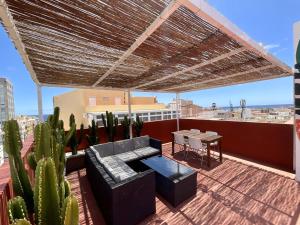 eine Dachterrasse mit einem Tisch, Stühlen und Kaktus in der Unterkunft Santa Cruz Luxury Low-Cost Apartment with Terrace & Views in Santa Cruz de Tenerife