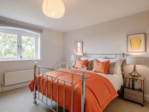 - une chambre avec un lit et une couette en orange dans l'établissement 3 Bed in Tenterden 83843, à Saint Michaels