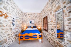 1 dormitorio con 1 cama en una pared de piedra en Villa See the Sea en Symi