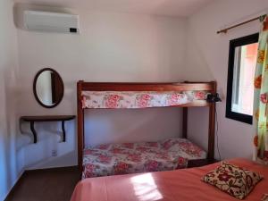 a bedroom with two bunk beds and a mirror at Chácara Santo Antonio in Brotas +65 photos