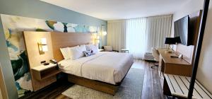 アトランタにあるWyndham Garden Atlanta Airportの大きなベッドとデスクが備わるホテルルームです。