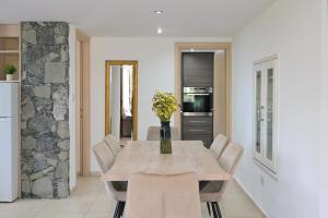 a dining room with a table with a vase of flowers at Oikou Thea Guesthouse in Oikos