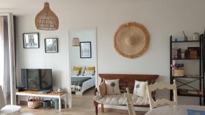 uma sala de estar com uma cadeira e uma televisão em Le Doux voyage T3, vue Mer, Wi Fi, PARKING gratuit em Toulon