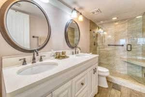a bathroom with a sink and a toilet and a mirror at Beach House Condominiums B101 - Beachfront with Pool, WiFi, & Beach Service in Destin