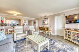 a living room with a couch and a table at Beach House Condominiums B101 - Beachfront with Pool, WiFi, & Beach Service in Destin