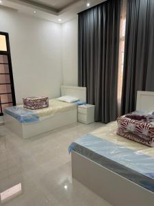 a room with two beds and a window at فيلا وشقق السعادة - صلالة in Salalah