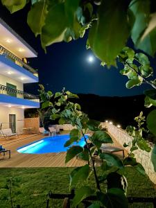 una casa con piscina por la noche en Olive Villa en Xirokámbion