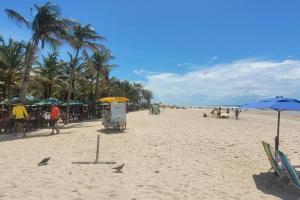 a beach with umbrellas and people on the beach at Kitnet Mobiliada itapua Vila Velha in Vila Velha