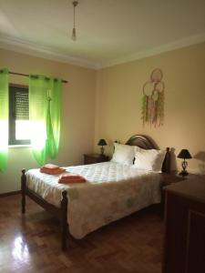 a bedroom with a large bed with green lighting at CASA DOS GRILOS in Penacova