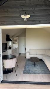 a living room with a couch and a table at HAVENZICHT HUISJE, chique ingericht, compleet uitgerust, prachtig uitzicht! in Belt-Schutsloot