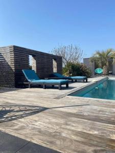 Jolie maison avec piscine et Spa في La Guerche-de-Bretagne: مسبح مع كرسي ازرق بجانب مسبح