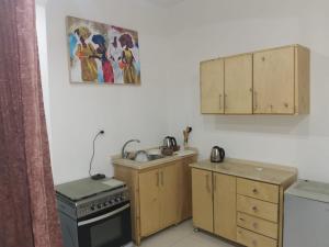 a kitchen with a stove and cabinets and a painting on the wall at Luxor family in Luxor