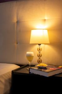 una lampada seduta su un tavolo accanto a un letto di Hotel America Chiclayo a Chiclayo