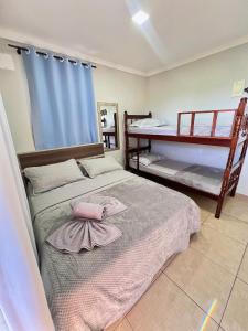 a bedroom with two beds and a bunk bed at Pôr-do-Sol Pousada in Penha