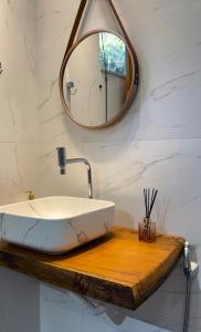 een badkamer met een wastafel en een spiegel bij Chalés Peterli 2 in Venda Nova do Imigrante