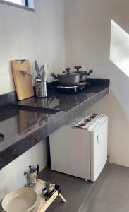 a kitchen with a counter with a stove and a sink at Chalés Peterli 2 in Venda Nova do Imigrante