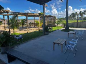 Casa Beira Mar Barra Sirinhaem في Sirinhaém: مجموعة من الكراسي وطاولة نزهة على الشاطئ