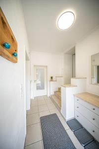 a kitchen with white cabinets and a tile floor at Schöne Ferienwohnung vor den Toren Pullman Citys zwei in Aicha vorm Wald