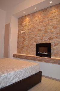 トロペアにあるVilla Oscarのレンガの壁のベッドルーム(暖炉付)