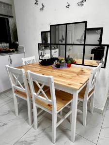 uma mesa de jantar branca com cadeiras brancas em SIYAY Apartment em Eilat