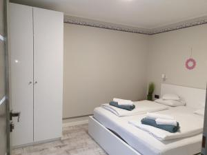twee bedden in een kamer met witte muren bij Pokoje Sandra I in Łeba