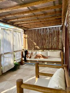 a person laying on a bed on a porch at Swiss Garten Jeri in Jericoacoara