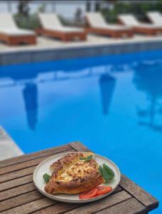 a plate of food on a table near a swimming pool at Hotel Barbati Sea View B&B in Barbati