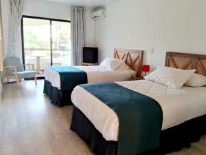 a hotel room with two beds and a window at Hotel Palmas de La Serena in La Serena
