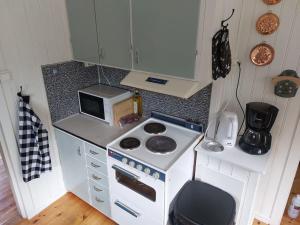 a small kitchen with a stove and a microwave at Elanden rust in Edebäck