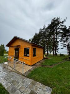 uma pequena casa de madeira num campo com árvores em Vasaras mājiņa D1 