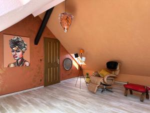 salon z pomarańczowymi ścianami i obrazem kobiety w obiekcie Remedium Appartements w mieście Vlotho