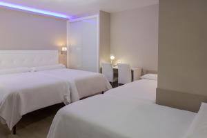 カンガス・デ・モラソにあるオテル フカマールのホテルルーム ベッド2台&紫色のライト付
