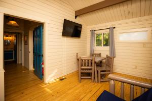 een veranda met een tafel en een televisie aan de muur bij Carowinds Camp Wilderness in Charlotte