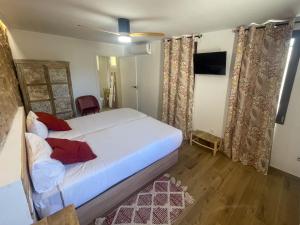 1 dormitorio con 1 cama blanca grande con almohadas rojas en Estancia dos Olivos, en Quesa