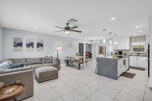 a living room with a couch and a kitchen at Salt Water Heated Pool Home with a Tiki Bar, a Garage Game Room and 4 Bikes in Naples