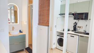 una cucina con mobili bianchi, lavatrice e asciugatrice di CapSexy Port Nature Garden Naturist Village a Cap d'Agde