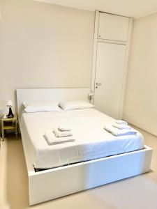Cama blanca en habitación blanca con paredes blancas en Milan City Smart, en Cologno Monzese
