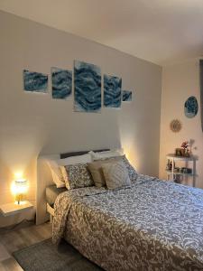 a bedroom with a bed and four paintings on the wall at Chez Isabelle in Saint-Paul-de-Vence