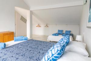 1 dormitorio con 2 camas y almohadas azules y blancas en AB Properties -Design House Marbella- 3 mn de Puerto Banus Beach - Golden Mile - Tropical Garden and Pool, en Marbella