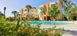 een resort met een zwembad en palmbomen bij Green Garden Resort in Hurghada