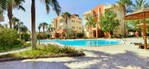 un complejo con piscina y palmeras en Green Garden Resort, en Hurghada